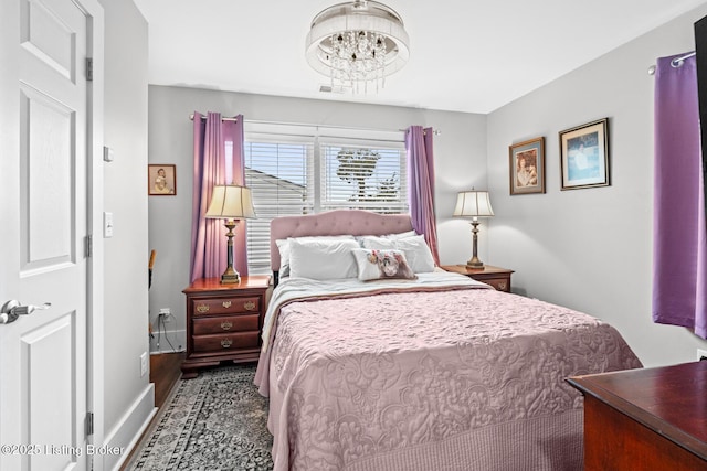 bedroom featuring a notable chandelier and baseboards
