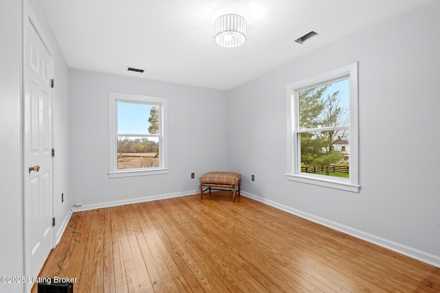 unfurnished bedroom featuring a chandelier, light wood-style flooring, baseboards, and visible vents