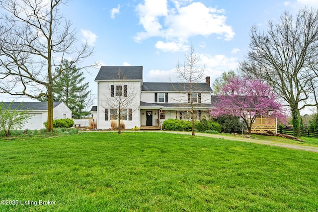 traditional-style house featuring a chimney and a front lawn