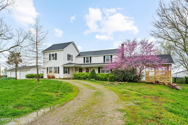 view of front of property with driveway, a chimney, and a front lawn