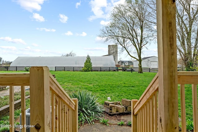 view of yard with fence and a rural view