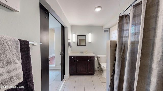 bathroom with vanity, visible vents, toilet, a stall shower, and baseboards