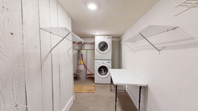 laundry room featuring water heater, stacked washer and dryer, a textured ceiling, carpet floors, and laundry area