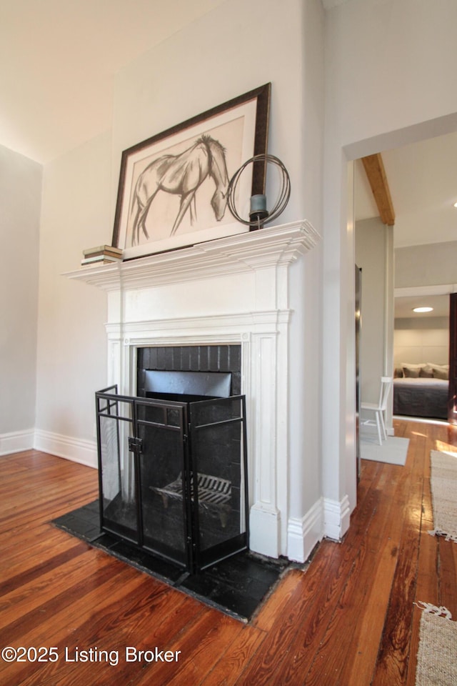 interior details featuring a fireplace, baseboards, and wood finished floors