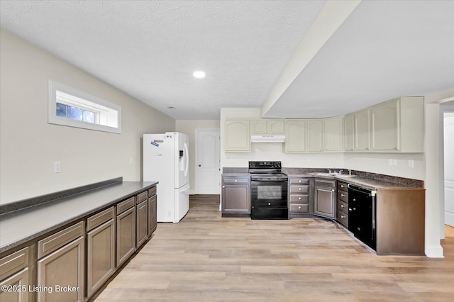 kitchen with dark countertops, a sink, black appliances, under cabinet range hood, and recessed lighting