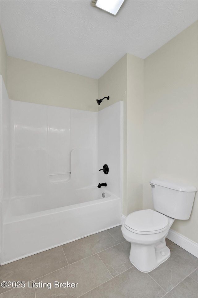 full bath featuring a textured ceiling, washtub / shower combination, baseboards, toilet, and tile patterned flooring