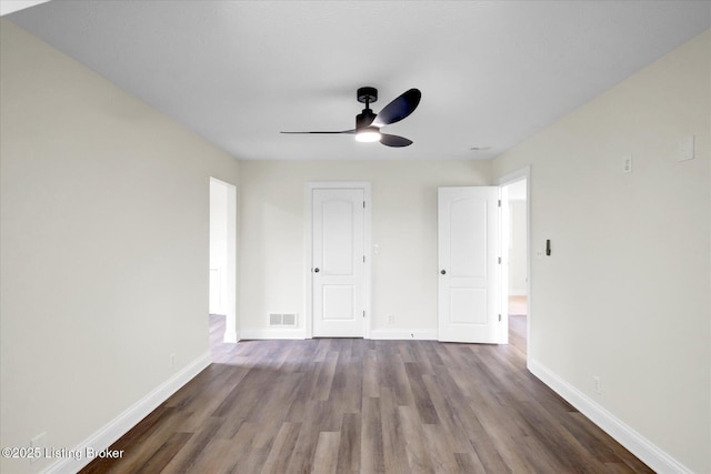 interior space with ceiling fan, baseboards, wood finished floors, and visible vents