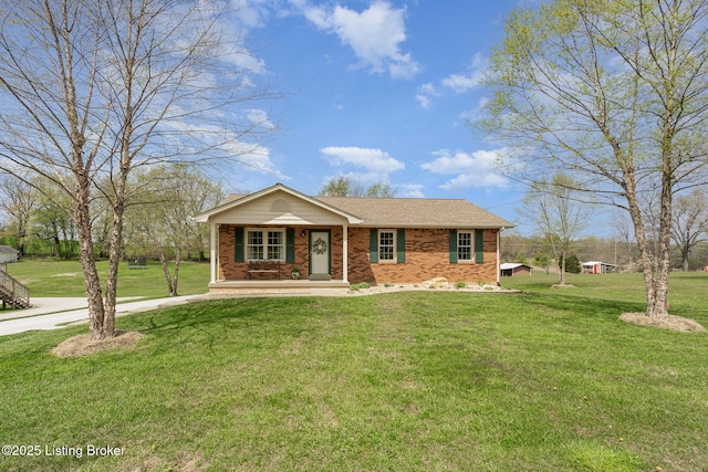view of front facade featuring a porch, a front lawn, brick siding, and concrete driveway