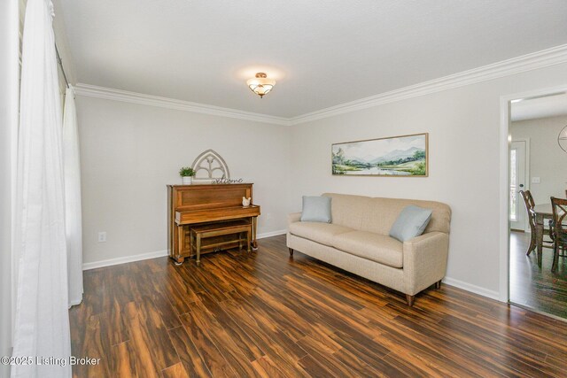 living area with baseboards, ornamental molding, and wood finished floors