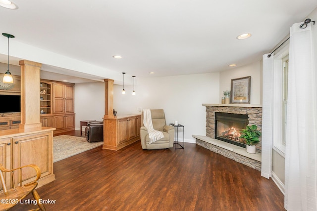 living area featuring baseboards, dark wood-style floors, a fireplace, and recessed lighting