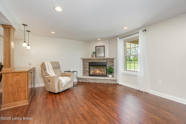 sitting room featuring dark wood-style flooring, baseboards, recessed lighting, ornate columns, and a fireplace