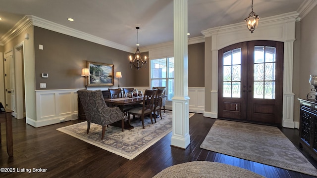 foyer entrance with crown molding, dark wood finished floors, ornate columns, a chandelier, and french doors