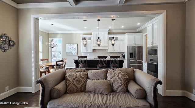 living area with a chandelier, dark wood-type flooring, baseboards, and ornamental molding