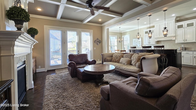 living area with baseboards, a fireplace, beam ceiling, coffered ceiling, and ceiling fan with notable chandelier