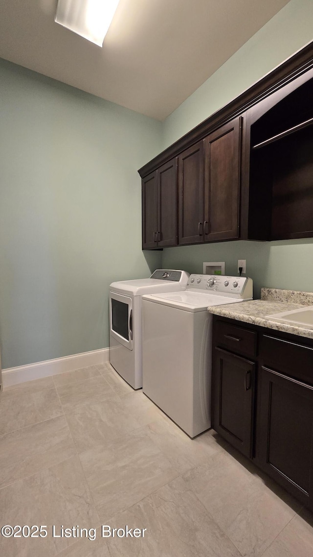 laundry area with a sink, washing machine and dryer, baseboards, and cabinet space