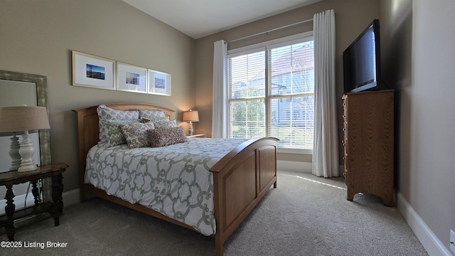 bedroom featuring light colored carpet and baseboards