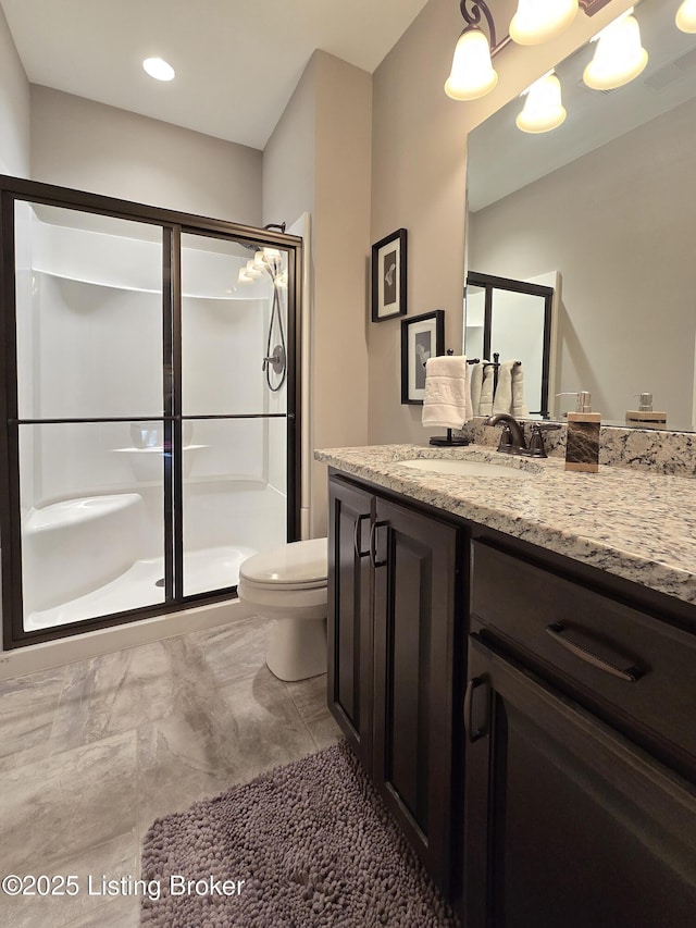 bathroom featuring a shower stall, vanity, visible vents, and toilet