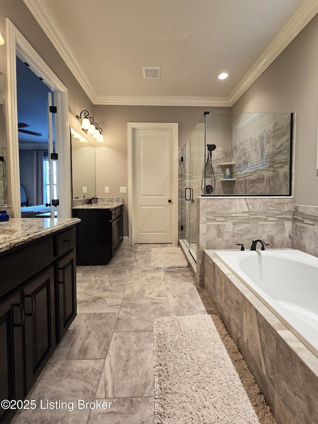 bathroom with visible vents, crown molding, a shower stall, vanity, and a garden tub
