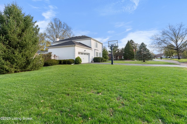 view of yard featuring aphalt driveway and an attached garage