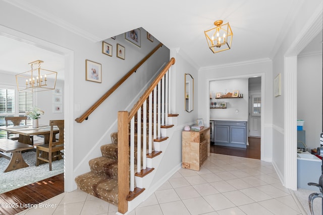 stairs featuring crown molding, tile patterned floors, an inviting chandelier, and baseboards