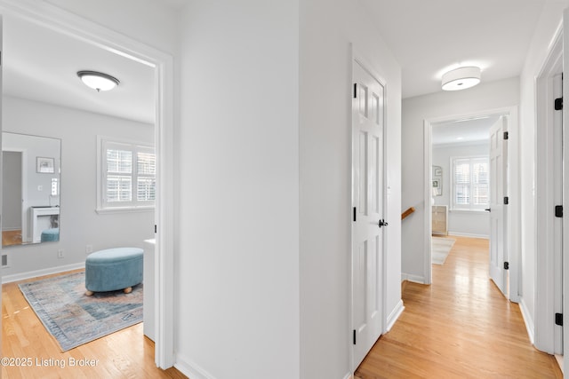 hallway featuring baseboards and light wood finished floors