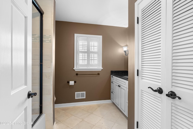 bathroom with visible vents, baseboards, vanity, and enclosed tub / shower combo