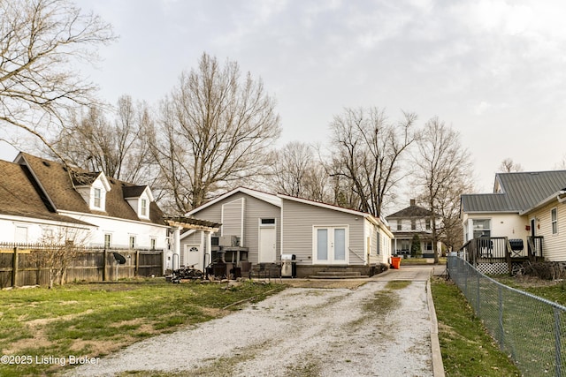 138 E Main St, Glendale, KY 42740 - back of property with french doors, a fenced backyard, a residential view, and driveway