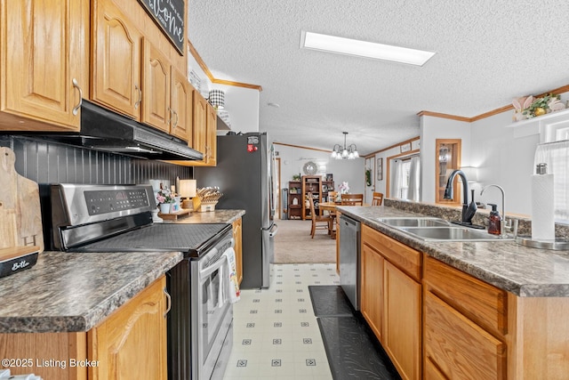 kitchen featuring a sink, appliances with stainless steel finishes, a textured ceiling, crown molding, and light floors