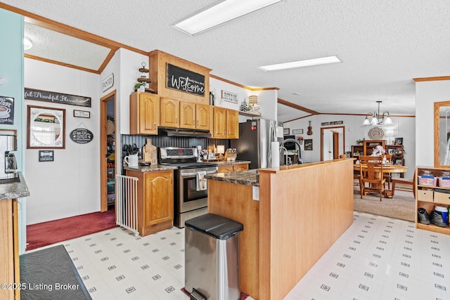 kitchen with a textured ceiling, crown molding, under cabinet range hood, lofted ceiling, and stainless steel appliances