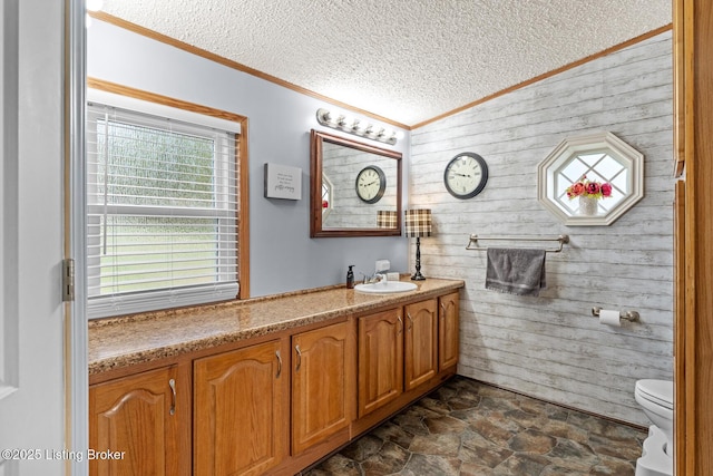 bathroom with crown molding, a textured ceiling, stone finish floor, toilet, and wooden walls