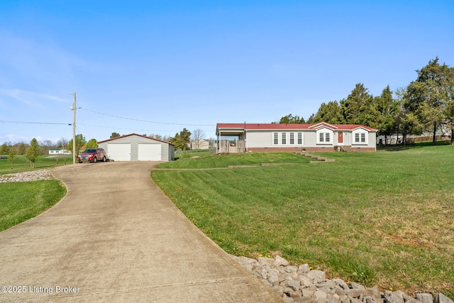 manufactured / mobile home featuring a garage, a front yard, and an outbuilding