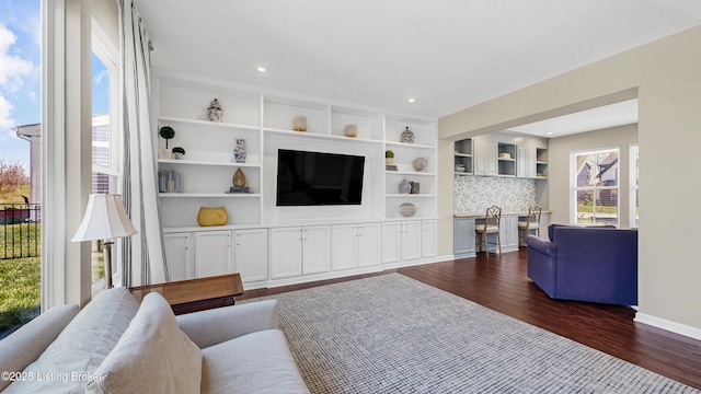 living room with recessed lighting, a healthy amount of sunlight, baseboards, and dark wood-style flooring
