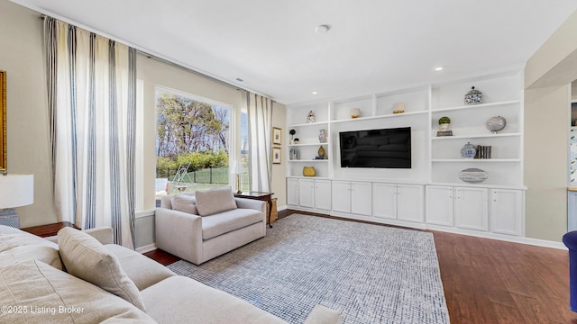 living area featuring baseboards, wood finished floors, and recessed lighting