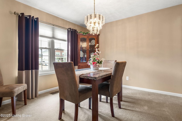 dining space featuring visible vents, light colored carpet, a notable chandelier, and baseboards