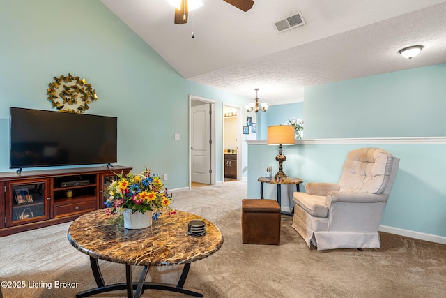 carpeted living area featuring visible vents, baseboards, lofted ceiling, and ceiling fan with notable chandelier