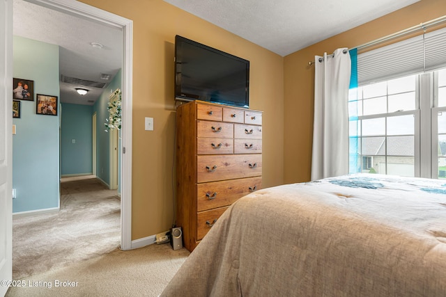 bedroom with visible vents, baseboards, a textured ceiling, and carpet floors