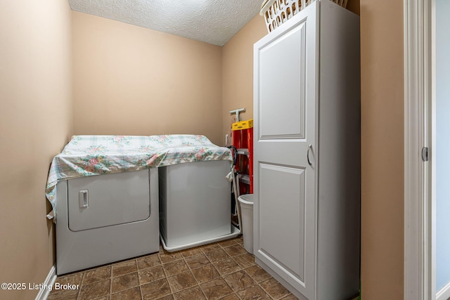 laundry area featuring separate washer and dryer, laundry area, and a textured ceiling