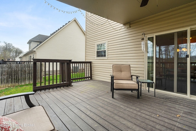 wooden deck with ceiling fan and fence