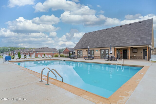 pool with a patio area and fence