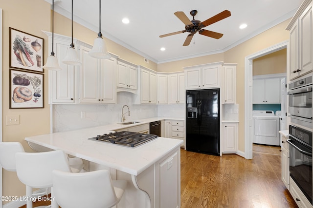 9502 Gerardia Ln, Prospect, KY 40059 - kitchen with black appliances, a sink, a peninsula, ceiling fan, and washer and clothes dryer