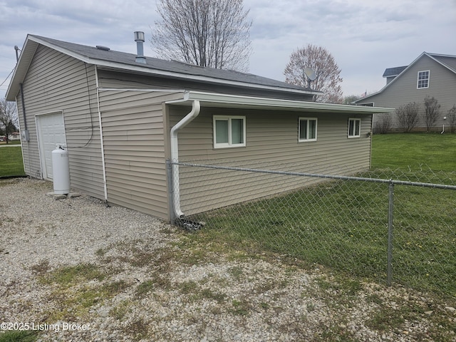 view of property exterior featuring fence, a lawn, and a garage