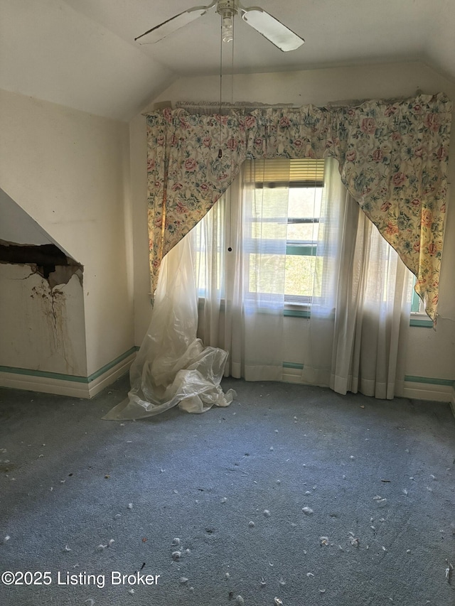 interior space featuring baseboards, vaulted ceiling, a ceiling fan, and carpet floors