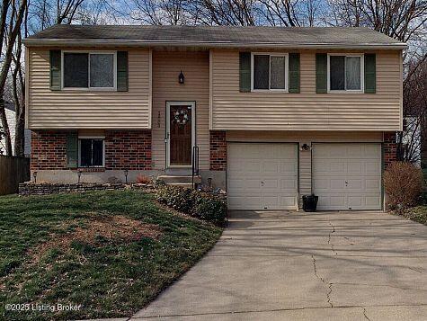 12003 Rustburg Ct, Louisville, KY 40245 - bi-level home featuring a garage, concrete driveway, and brick siding