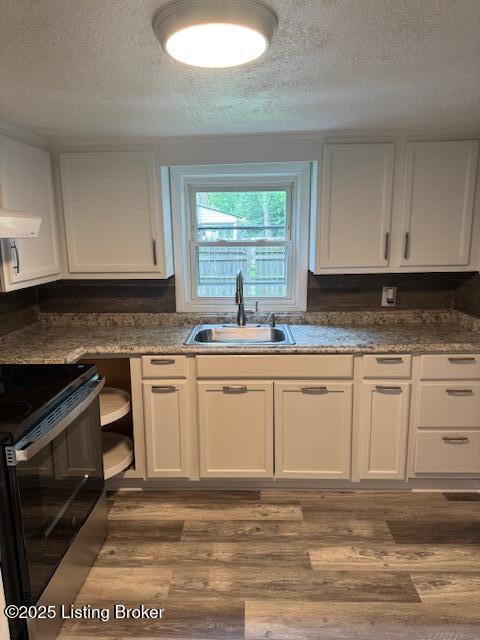 715 W Evelyn Ave, Louisville, KY 40215 - kitchen with a sink, electric range, a textured ceiling, white cabinets, and wood finished floors