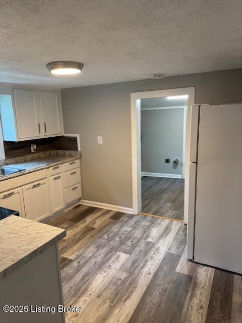 715 W Evelyn Ave, Louisville, KY 40215 - kitchen featuring freestanding refrigerator, a textured ceiling, dark wood-type flooring, and white cabinetry