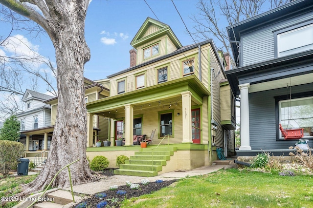 view of front of property with a porch and a front lawn