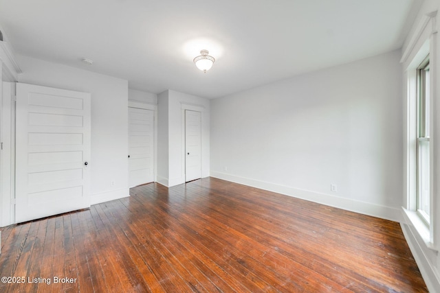 unfurnished bedroom with wood-type flooring and baseboards