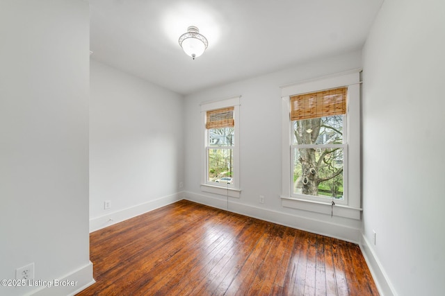 unfurnished room with wood-type flooring and baseboards