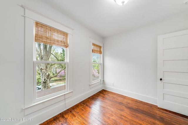 unfurnished room featuring hardwood / wood-style flooring and baseboards
