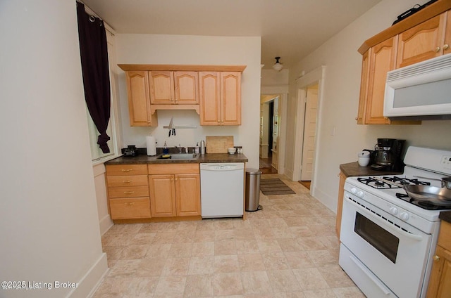 kitchen featuring light brown cabinets, a sink, dark countertops, and white appliances